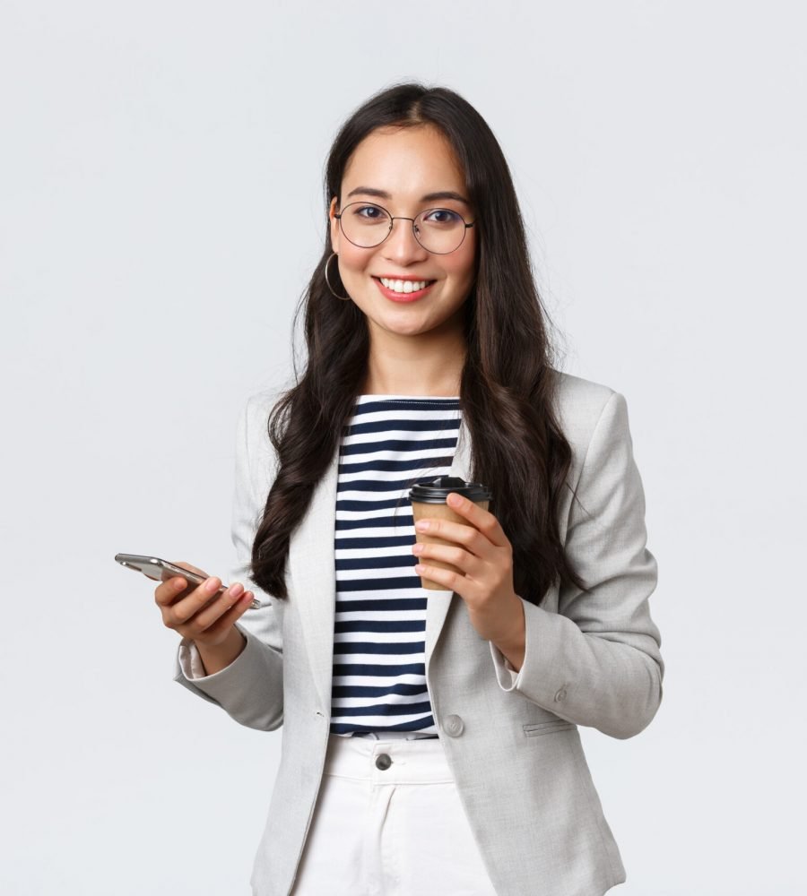Business, finance and employment, female successful entrepreneurs concept. Professional asian businesswoman in glasses, having lunch, drinking takeaway coffee and using mobile phone.